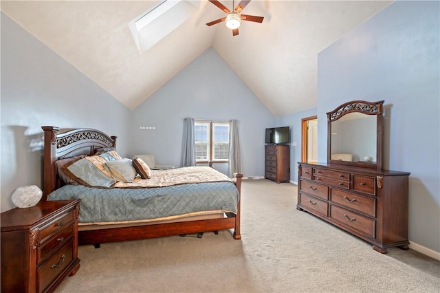 bedroom featuring ceiling fan, high vaulted ceiling, light carpet, a skylight, and baseboards