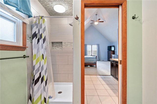 ensuite bathroom featuring connected bathroom, lofted ceiling, ceiling fan, tile patterned floors, and a shower stall