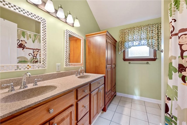 full bathroom featuring double vanity, tile patterned flooring, a sink, and baseboards