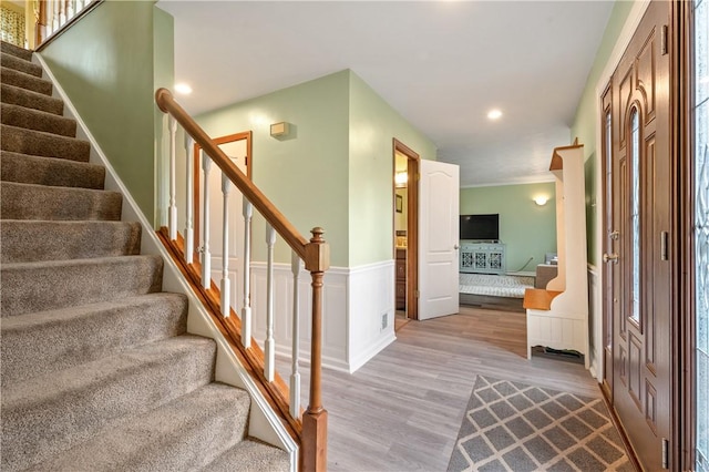 foyer featuring stairs, wainscoting, light wood-type flooring, and recessed lighting