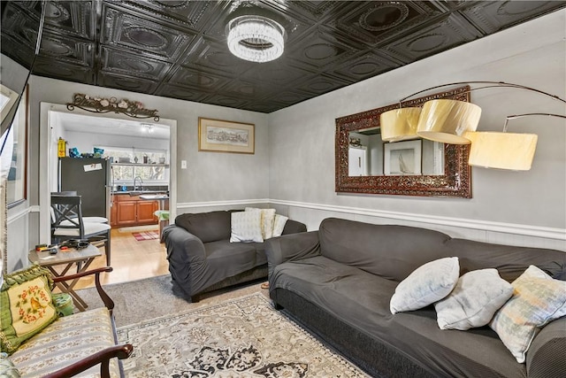 living room with an ornate ceiling and light wood-style flooring