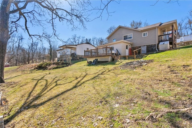 rear view of property featuring a lawn and a wooden deck