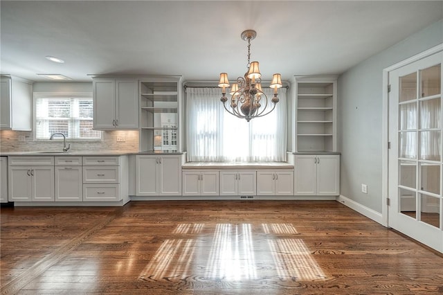 kitchen featuring dark wood-style flooring, a sink, backsplash, and open shelves