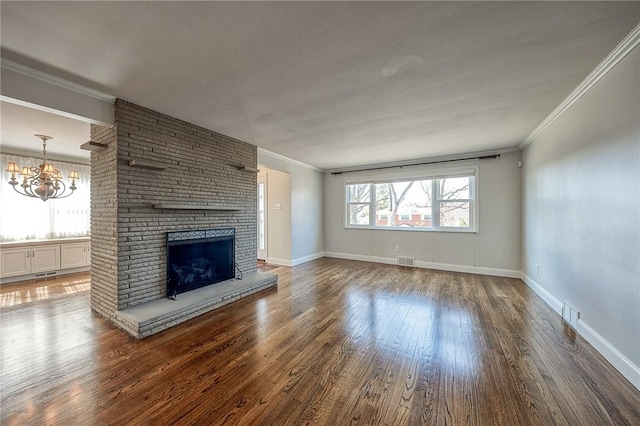 unfurnished living room featuring a brick fireplace, crown molding, baseboards, and wood finished floors