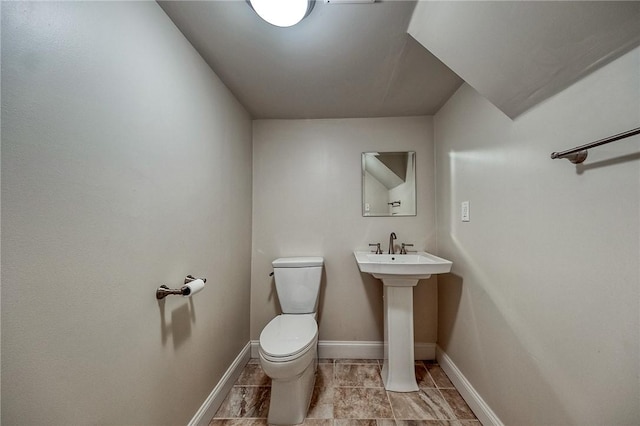 half bathroom with toilet and baseboards