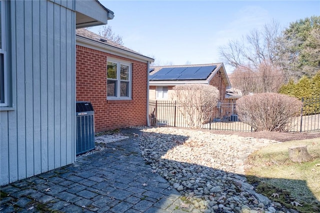 view of yard with fence, central AC, and a patio