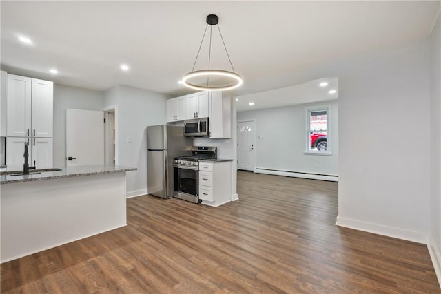 kitchen with a baseboard heating unit, stainless steel appliances, dark wood-style flooring, a sink, and white cabinets