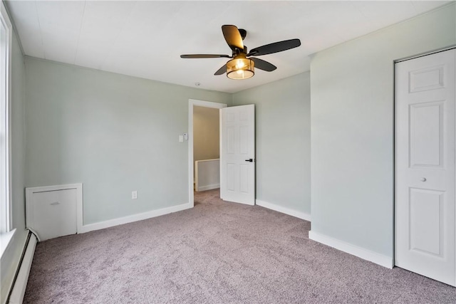 unfurnished bedroom with carpet, baseboards, baseboard heating, and a ceiling fan