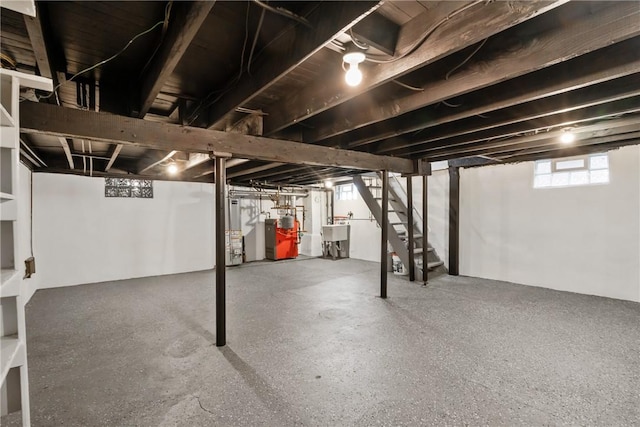 basement featuring a heating unit, a sink, and stairway