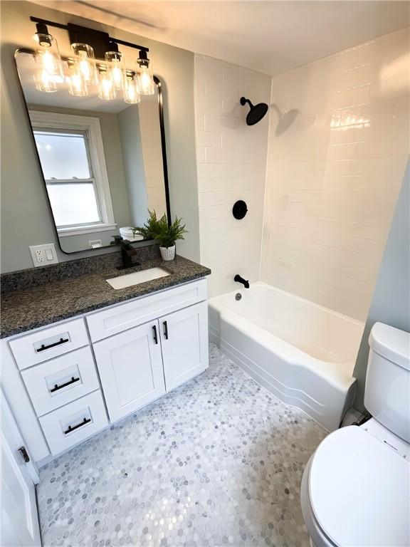 full bath featuring bathtub / shower combination, vanity, and toilet