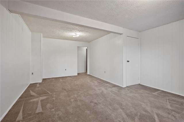 carpeted spare room with a textured ceiling