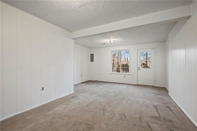 carpeted spare room featuring electric panel and a textured ceiling