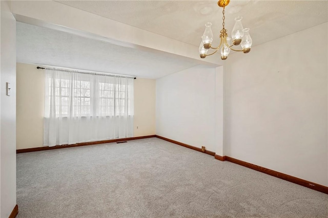 unfurnished room featuring carpet floors, a chandelier, visible vents, and baseboards