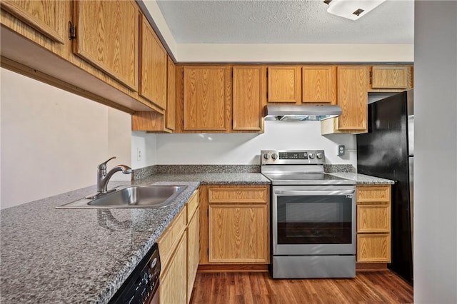 kitchen featuring exhaust hood, a sink, electric stove, freestanding refrigerator, and dark wood-style floors