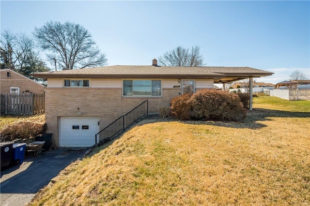 exterior space featuring a garage, brick siding, fence, driveway, and a yard