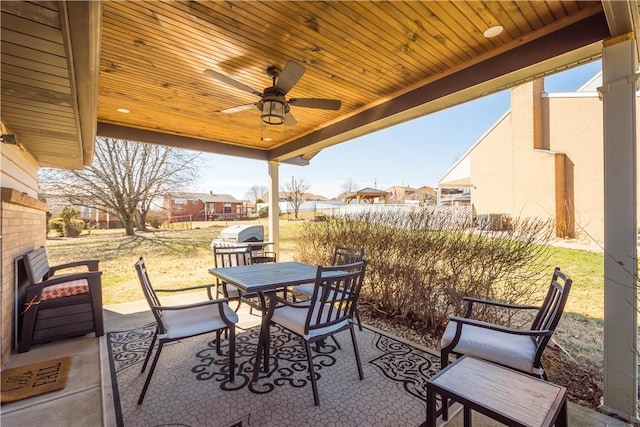 view of patio / terrace with ceiling fan, outdoor dining space, a grill, and a residential view