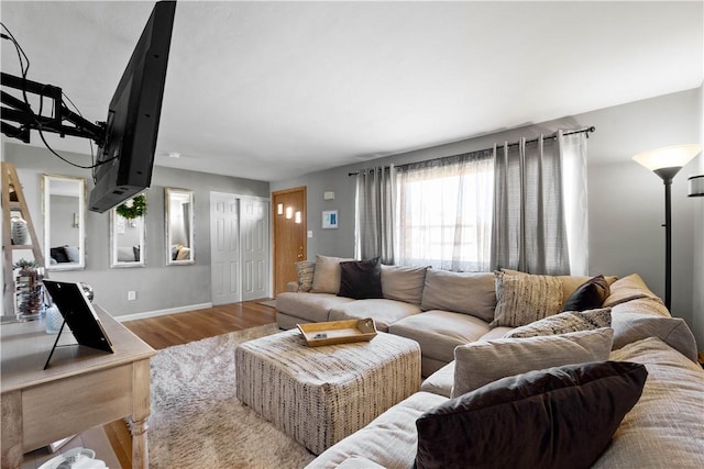 living area with baseboards and wood finished floors