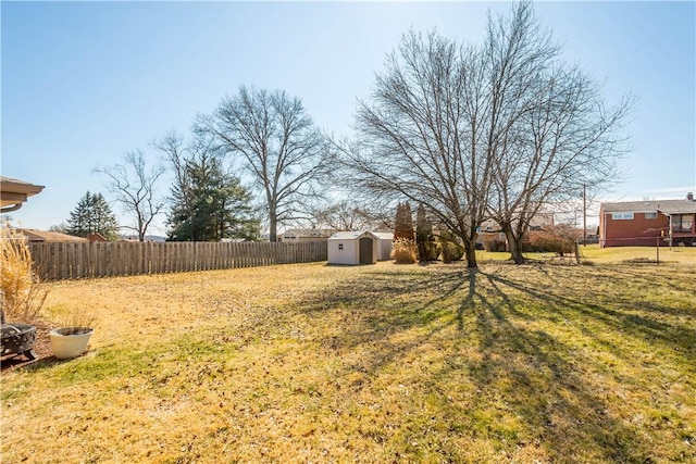 view of yard with a storage unit, an outdoor structure, and a fenced backyard