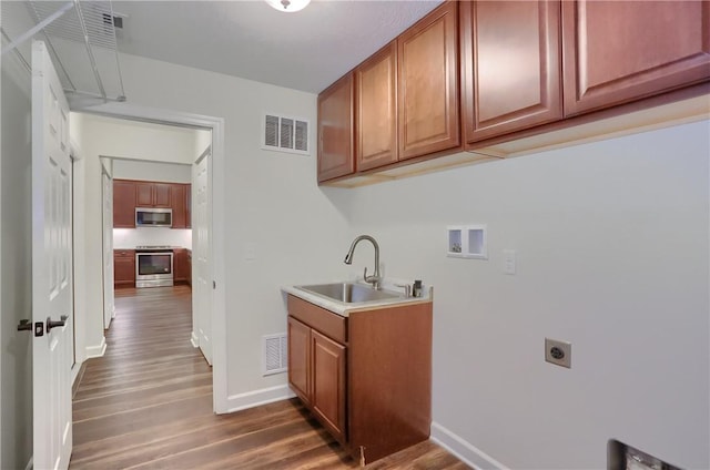 laundry area featuring cabinet space, visible vents, hookup for a washing machine, and a sink