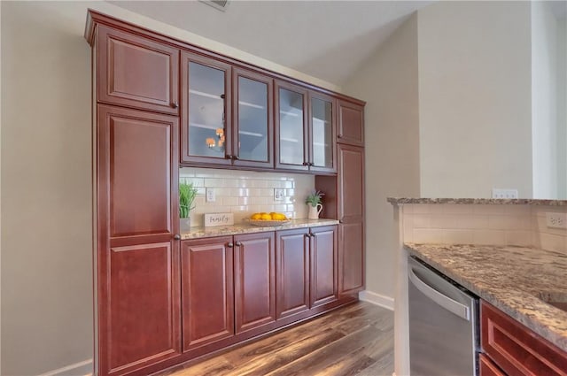 bar with stainless steel dishwasher, decorative backsplash, baseboards, dark wood-style flooring, and vaulted ceiling