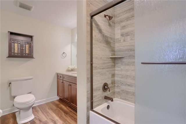 bathroom with vanity, washtub / shower combination, wood finished floors, visible vents, and toilet