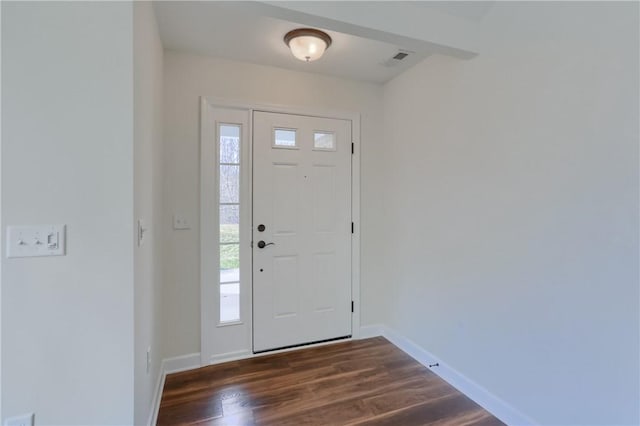 foyer entrance featuring a wealth of natural light, dark wood-style floors, visible vents, and baseboards