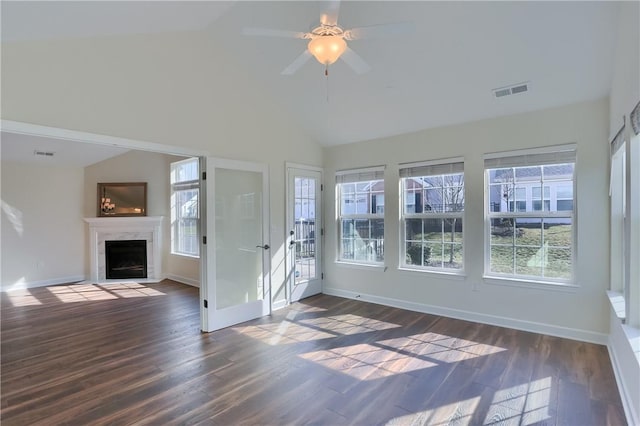 unfurnished living room with a premium fireplace, visible vents, dark wood-style floors, and vaulted ceiling