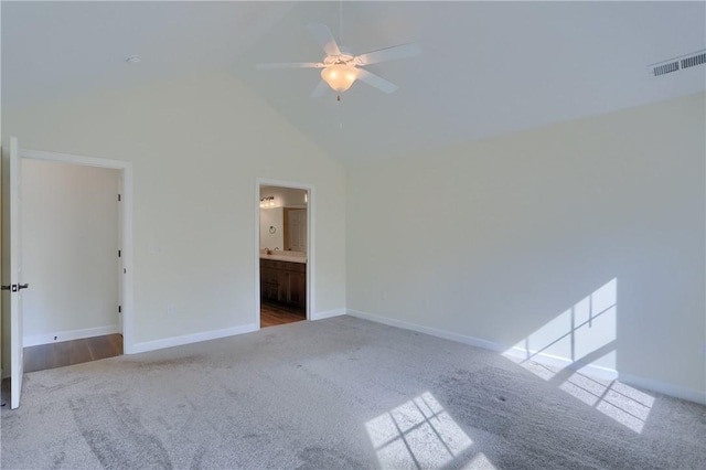 interior space with baseboards, carpet flooring, high vaulted ceiling, and visible vents