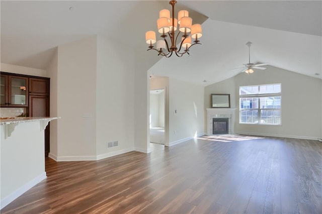 unfurnished living room with visible vents, a tile fireplace, ceiling fan with notable chandelier, dark wood finished floors, and vaulted ceiling