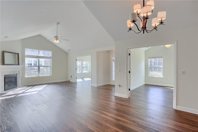 unfurnished living room with a wealth of natural light, a premium fireplace, lofted ceiling, and dark wood-type flooring