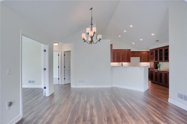 unfurnished living room featuring visible vents, baseboards, a notable chandelier, and wood finished floors