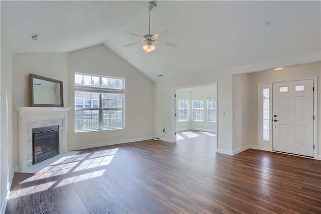 unfurnished living room with baseboards, lofted ceiling, wood finished floors, and a fireplace