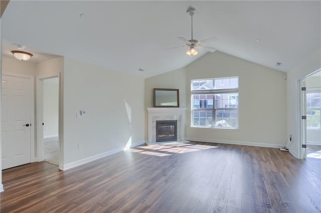 unfurnished living room with a fireplace with flush hearth, a healthy amount of sunlight, and wood finished floors