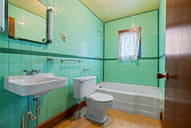 full bath featuring toilet, a sink, and tile walls