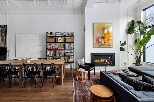 interior space featuring hardwood / wood-style floors, a glass covered fireplace, and an ornate ceiling