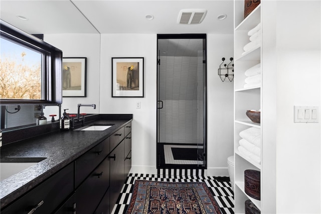 full bath with visible vents, toilet, a stall shower, a sink, and baseboards