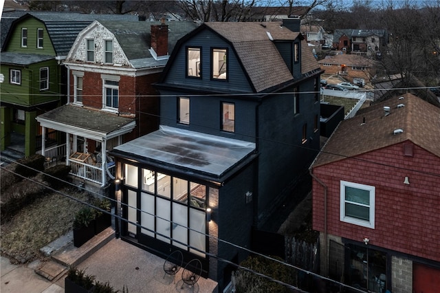 view of front of home featuring a residential view and a gambrel roof