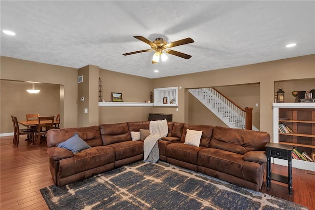 living area with ceiling fan, wood finished floors, stairs, a textured ceiling, and recessed lighting