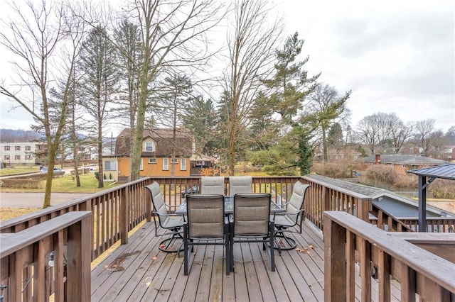 wooden terrace with a residential view and outdoor dining area