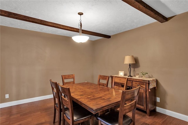 dining space with baseboards, dark wood-type flooring, and beam ceiling