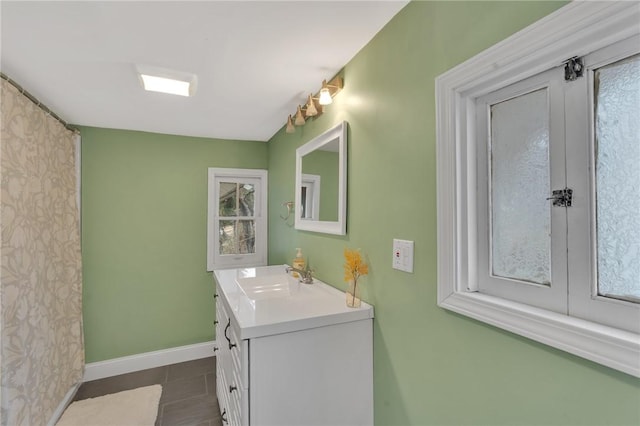 bathroom with tile patterned flooring, vanity, and baseboards