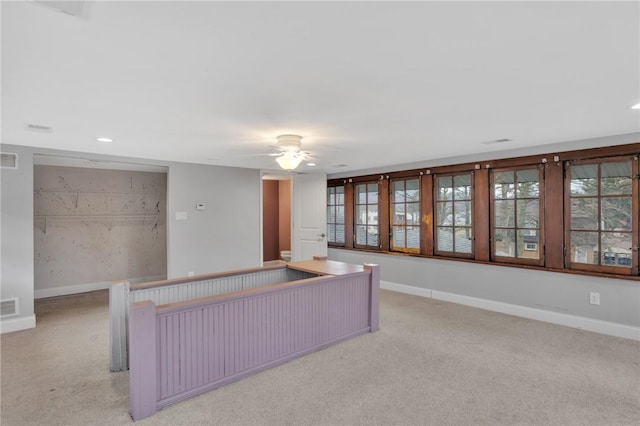 unfurnished living room with visible vents, light colored carpet, and baseboards