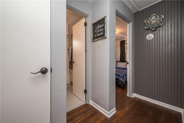 corridor with baseboards and wood finished floors