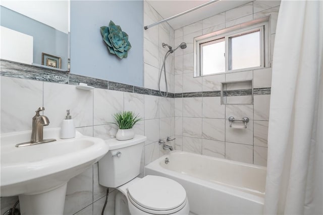 bathroom featuring shower / bath combo, a sink, tile walls, and toilet