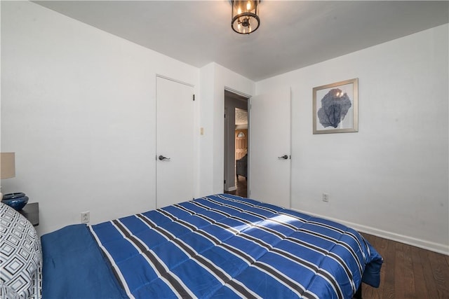 bedroom with baseboards and wood finished floors