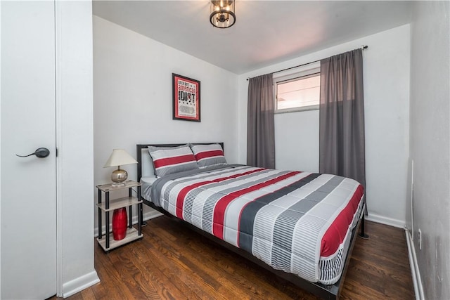 bedroom with wood finished floors and baseboards