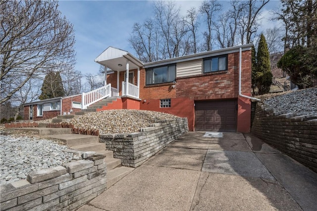 single story home featuring driveway, a garage, and brick siding