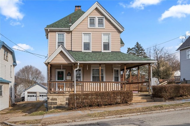 view of front of property featuring covered porch, an outdoor structure, a detached garage, roof with shingles, and a chimney