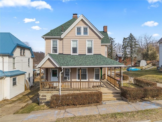 view of front of property featuring covered porch, a shingled roof, and a chimney