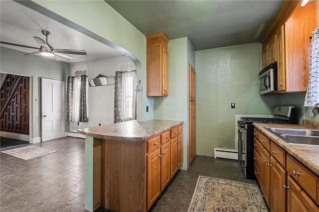 kitchen with arched walkways, brown cabinetry, ceiling fan, appliances with stainless steel finishes, and a sink